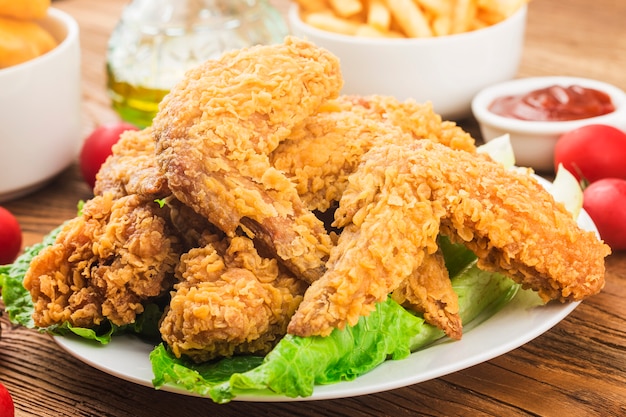 Asas de frango frito na mesa de madeira.