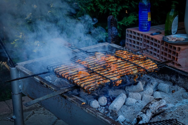 asas de frango grelhadas. Churrasco na floresta. Cozinhar frango no barril com uma grelha. Churrasco