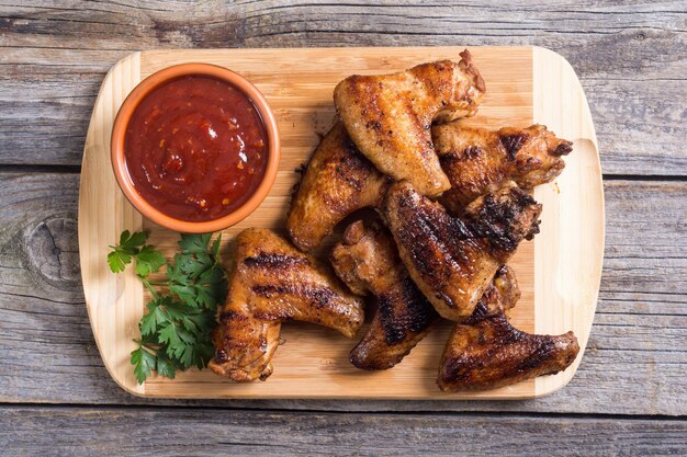 asas de frango grelhadas com molho de tomate e salsa