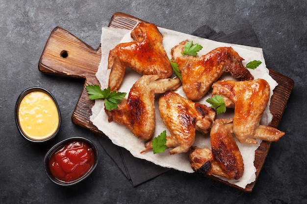 asas de frango grelhadas quentes com molho Vista superior na mesa de pedra