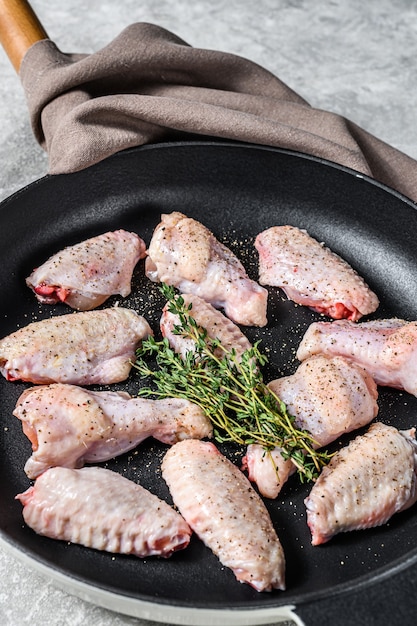 Asas de frango marinado com especiarias e ervas em uma panela