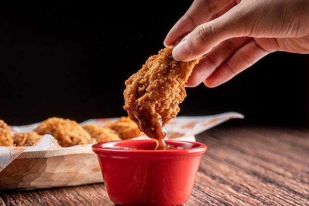 Foto asas de frango mergulhadas em ketchup