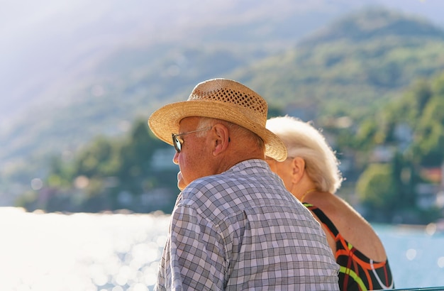 Ascona, Schweiz - 23. August 2016: Älteres Paar sitzt auf der Bank am Ufer des teuren Ferienortes Ascona am Lago Maggiore, Kanton Tessin in der Schweiz.