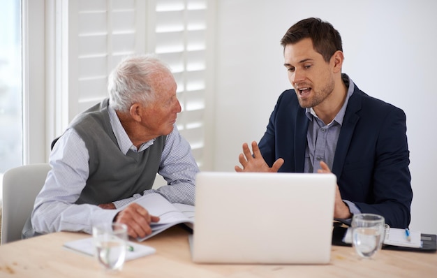 Asegurándose de que entienda completamente Un joven hombre de negocios explicando información a un anciano