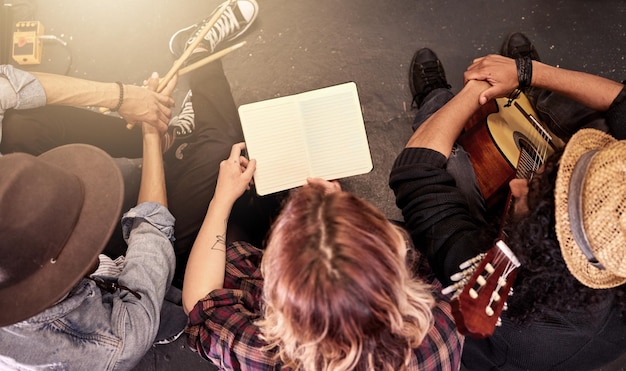 Asegurándose de que tienen la música abajo. Toma en ángulo alto de una banda irreconocible leyendo su partitura en el escenario antes de un concierto.