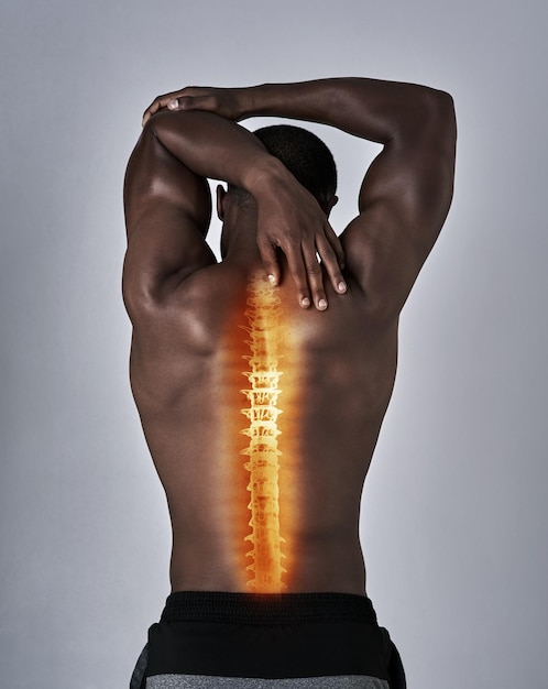 Asegurarse de que cada músculo esté listo Vista trasera de un joven atlético calentándose con una lesión en la espalda