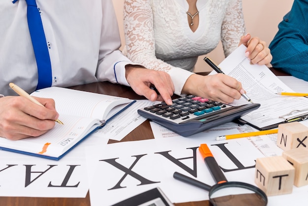 Asesor calculando y ayudando a la mujer a llenar 1040