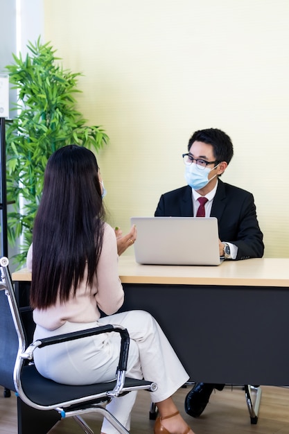 Asesor comercial asesorar al cliente sobre la inversión. Ambas personas fueron mascarilla.