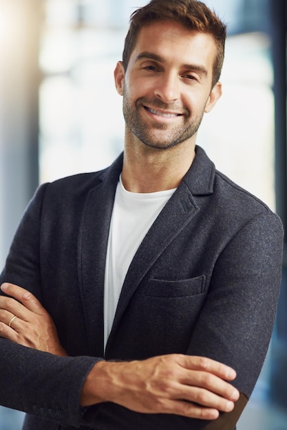 Asesor financiero retrato y confiado en el lugar de trabajo para la confianza de la empresa o sobre nosotros con feliz o sonrisa hombre de negocios cara y profesional para el crecimiento con experiencia conocimiento y brazos cruzados