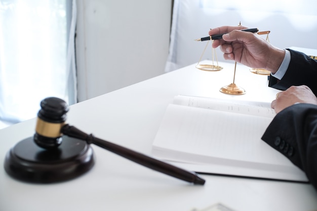 El asesor legal presenta al cliente un contrato firmado con martillo y derecho legal. concepto de justicia y abogado.