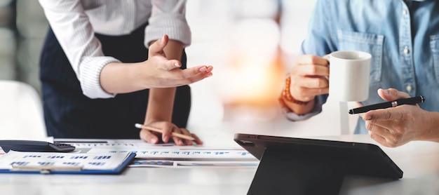 Asesor de negocios dos personas de negocios hablando de planificación analizar inversiones y marketing en tableta en la oficina