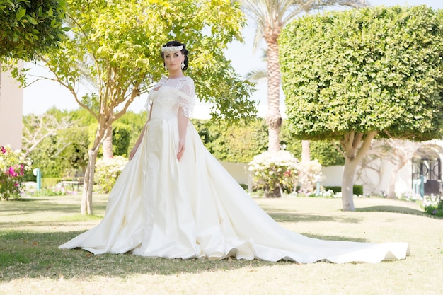 Asesoramiento y consejos de expertos en bodas en el extranjero. Vestido de cuento de hadas. Considerar las cosas para la boda en el extranjero. Novia adorable vestido de novia blanco día soleado palmera fondo. Isla tropical de ceremonia de boda.