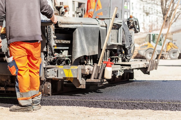 Asfaltado de obras viales Pavimentadora de asfalto con máquinas pesadas Colocación de asfalto en una nueva carretera