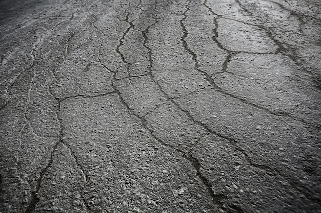 Asfalto en grietas textura / fondo abstracto grietas en la carretera asfaltada