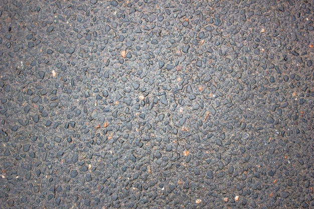 Asfalto molhado com a adição de pedras Estrada após a chuva Fundo de textura