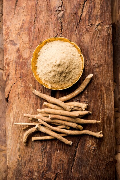 Ashwagandha o Aswaganda O Indian Ginseng es una medicina ayurvédica en forma de tallo y polvo. Aislado sobre fondo liso. enfoque selectivo