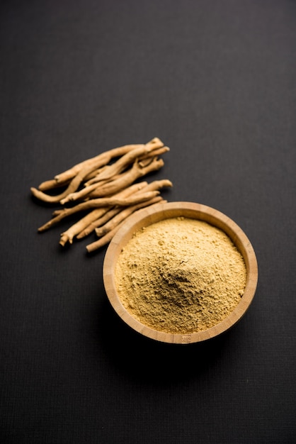 Ashwagandha oder Aswaganda ODER Indischer Ginseng ist ein Ayurveda-Medikament in Stiel- und Pulverform. Auf einfachen Hintergrund isoliert. selektiver Fokus