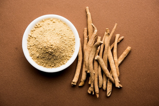 Ashwagandha ou Aswaganda OU Ginseng Indiano é um medicamento Ayurveda em forma de caule e pó. Isolado em fundo liso. foco seletivo