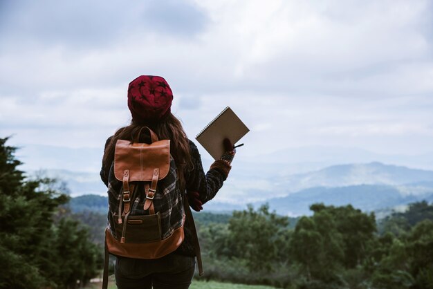 Asia joven sostiene un cuaderno en las montañas pico doi inthanon en Chiang Mai, Tailandia