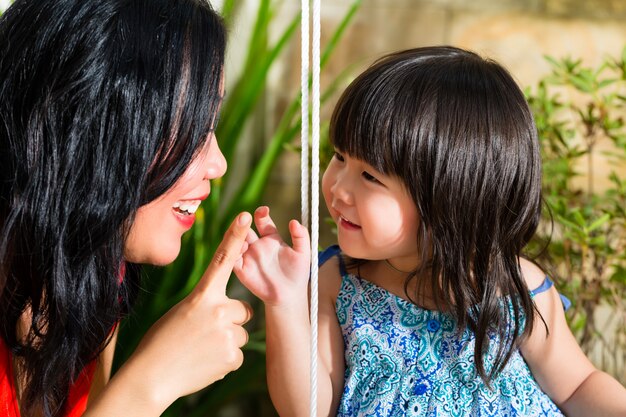 Asia madre e hija en su casa en el jardín