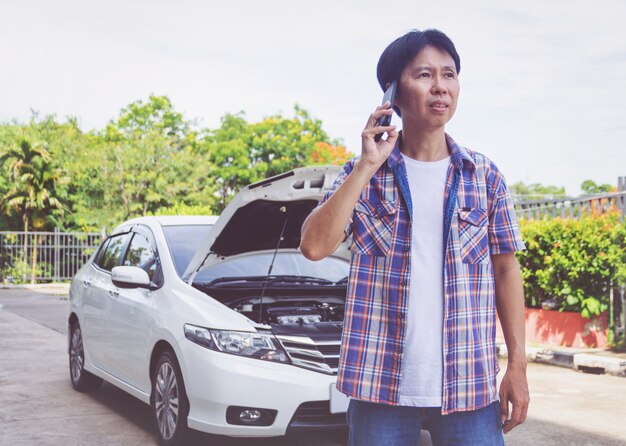 Asia man stand frente um carro quebrado pedindo ajuda