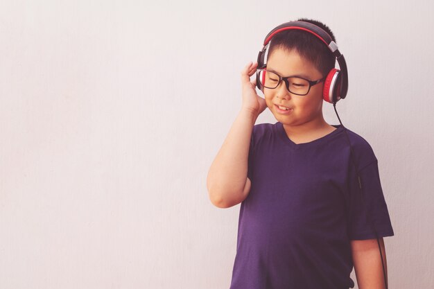 Asia muchacho con auriculares escuchando música.