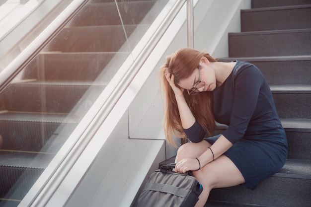 Asia mujer estresada del trabajo sentado en pasos afuera