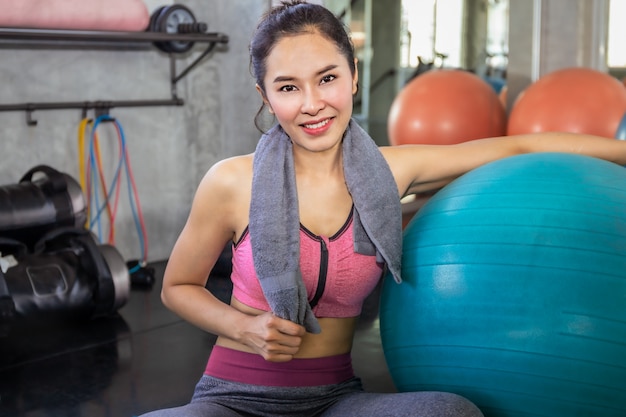 Asia mujer en forma y saludable sonriendo en el gimnasio después del entrenamiento.