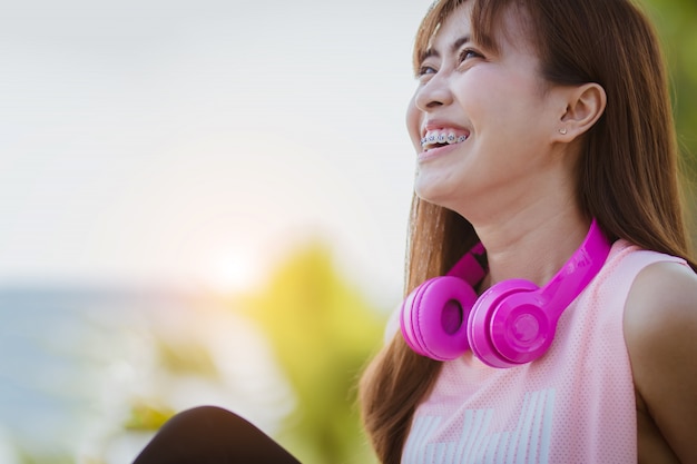 Asia mujer sentada escuchando música relajarse después del ejercicio