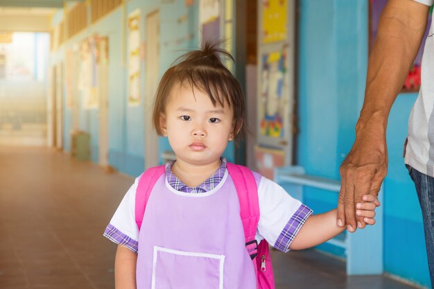 Asia preescolar niña estudiante en general uniforme y bolso rojo ir a la escuela, de regreso a la escuela.