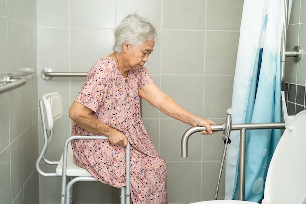 Asia senior o anciana anciana mujer paciente uso inodoro baño manejar seguridad en enfermería sala de hospital saludable fuerte concepto médico