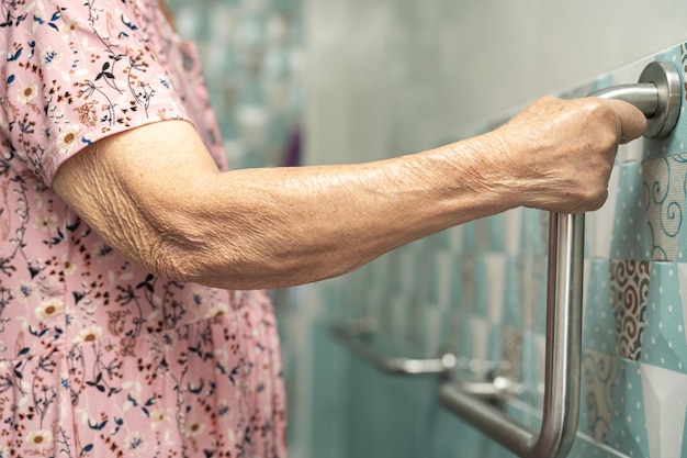 Asia senior o anciana anciana mujer paciente uso inodoro baño manejar seguridad en enfermería sala de hospital saludable fuerte concepto médico