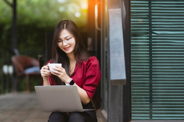 Asia Woman arbeitet am PC und Smartphone bei der Arbeit von zu Hause aus