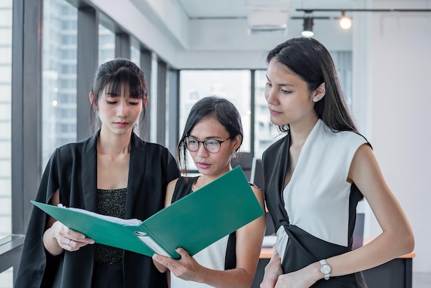 Asian Business drei Frauen schauen Dokumentenordner im modernen Büro