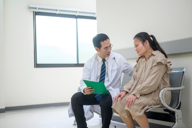 Asian Doctor está trabajando en el hospital hablando con tristeza mujer atención médica conceptx9