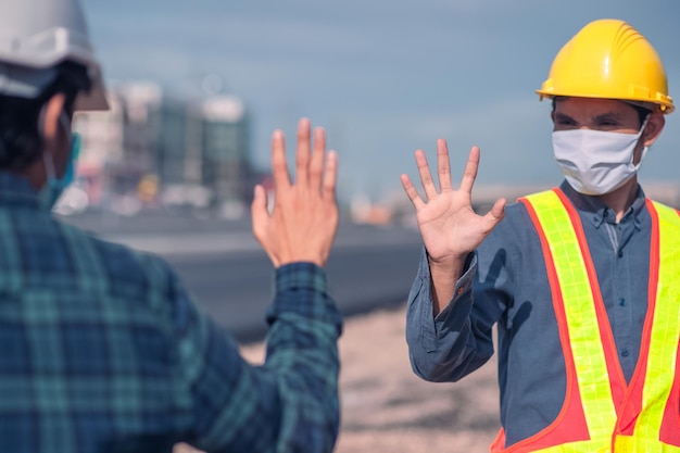 Asian Engineer Construction sind Arbeiter, die mit einem Sicherheitskontrollhelm vor Ort arbeiten