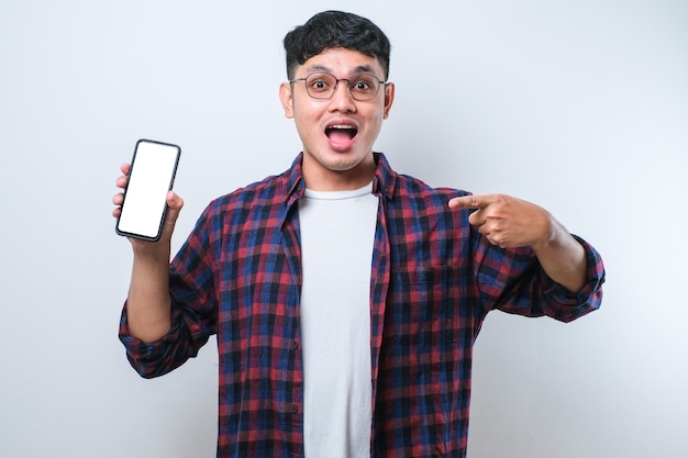 Asian Guy Smile mirando a la cámara mostrando la pantalla vacía del teléfono inteligente recomendando la aplicación
