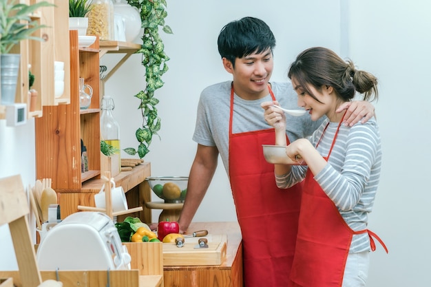 Asian Lover o pareja de cocina y degustación de alimentos en la sala de la cocina en la casa moderna, pareja yl