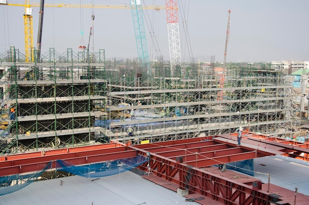 Asiaten und thailändische Arbeiter mit schweren Maschinen arbeiten Baumeister Neubau auf Baustelle Hochhaus auf Gerüst in der Hauptstadt Bangkok Thailand