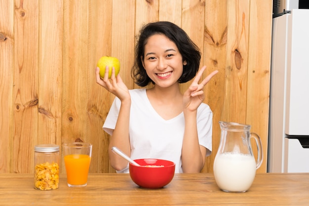 Asiática joven desayunando y con una manzana