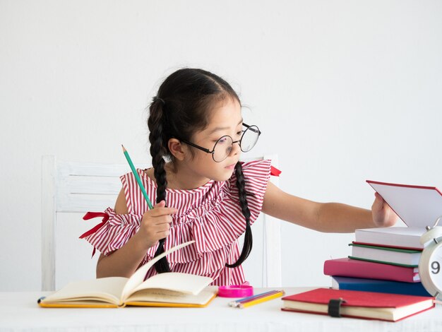 Asiática linda garota com um livro na mesa