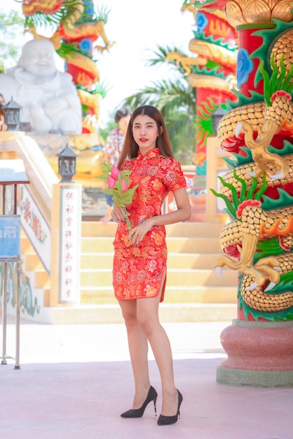 Asiática linda mulher usando vestido vermelho no ano novo chinês