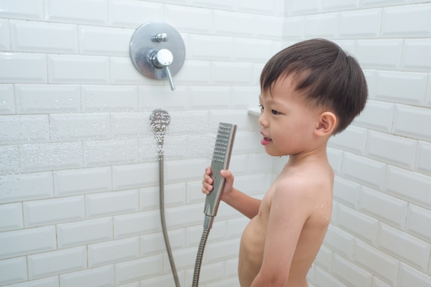 Asiático de 3 a 4 años de edad, niño pequeño niño ducharse solo