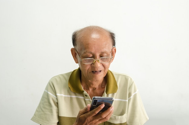 Asiático careca usando óculos e usando um telefone