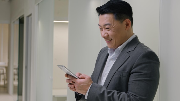 Asiático de mediana edad sonriente hombre de negocios chino japonés coreano feliz hombre de negocios empleador CEO