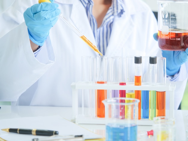 Asiático serio femenino químico trabajando en laboratorio