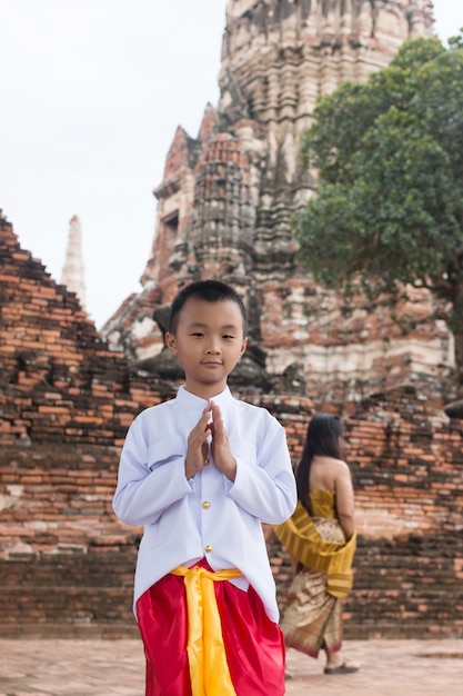 Asiatico con vestido tailandés en el antiguo templo