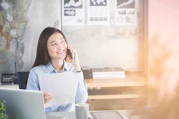 Asiatin arbeiten glücklich im Büro