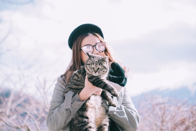 Asiatin, die draußen eine Katze in Japan-Winter hält