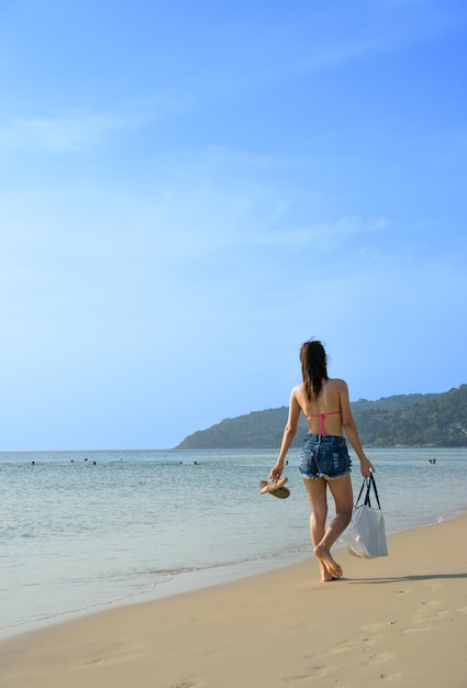 Asiatin, die entlang den Strand geht